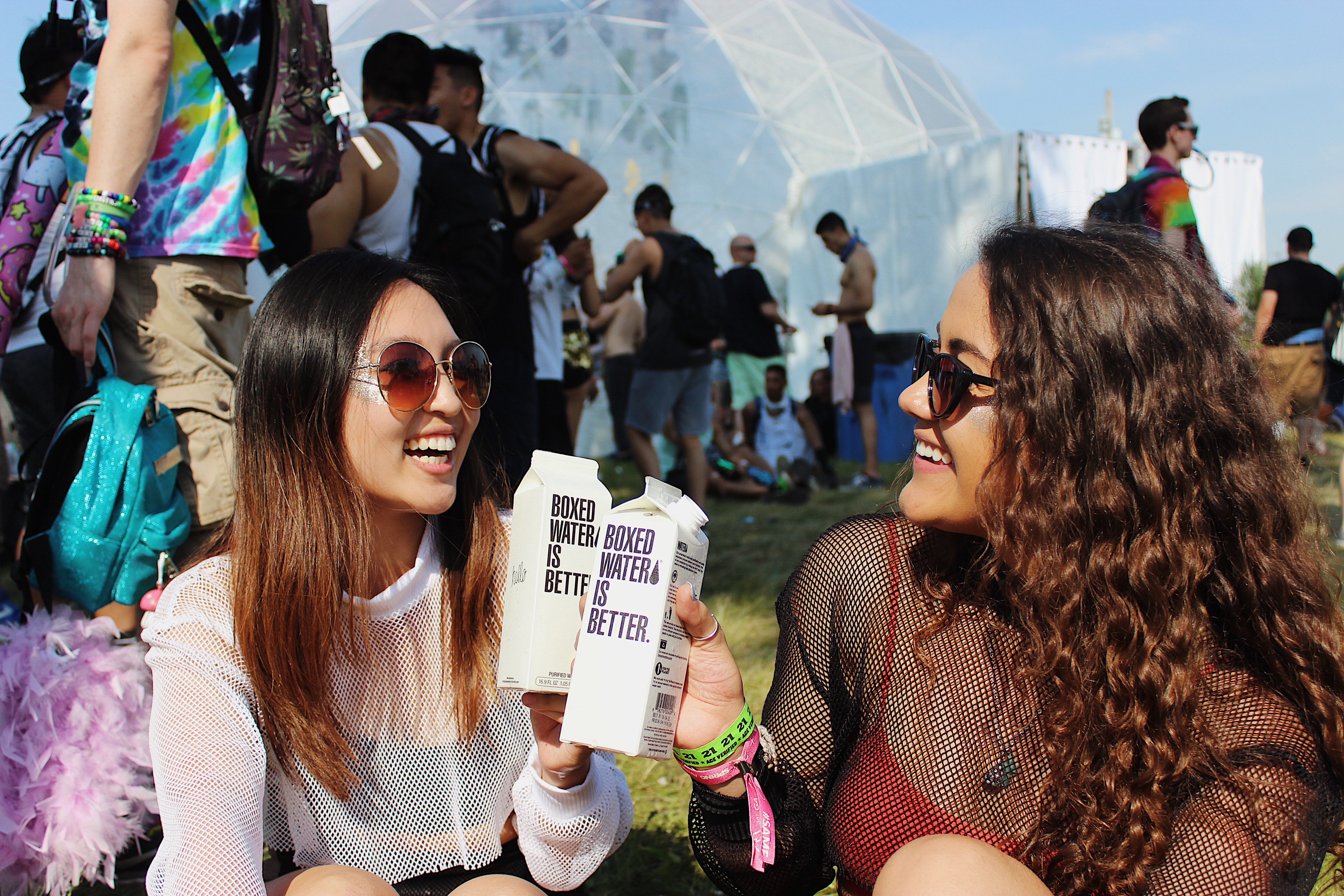 Two woman holding Boxed Water cartons